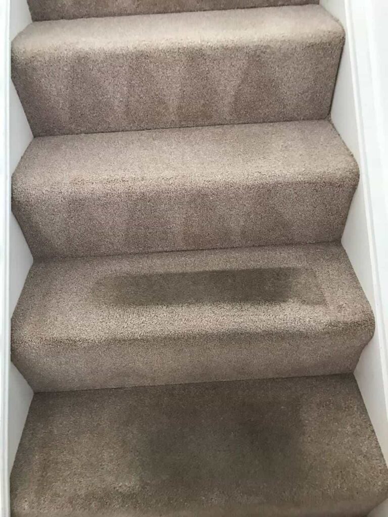 this is a photo of a staircase with beige carpets that is in the process of being cleaned works carried out by Purley Carpet Cleaning Solutions.